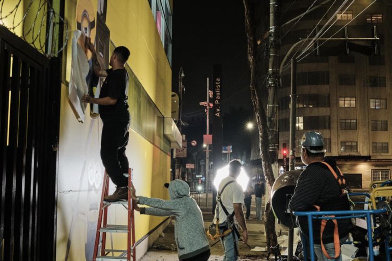 Equipe de instalação trabalhando na fachada durante a madrugada na Avenida Paulista